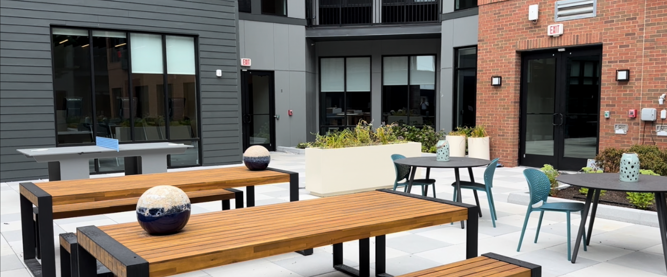 Private outdoor courtyard at The Rail at Bound Brook with modern seating, ping pong table, and landscaped planters – pet-friendly apartments with outdoor amenities in Bound Brook, NJ.